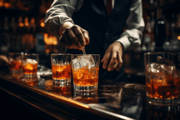 bartender stirring two glasses of whiskey with ice